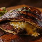 Elevate Your Meals with Easy Steak Quesadilla Magic 9 Golden steak quesadilla with melted cheese and guacamole on a wooden table