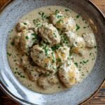 Creamy garlic chicken with fresh herbs on a wooden table